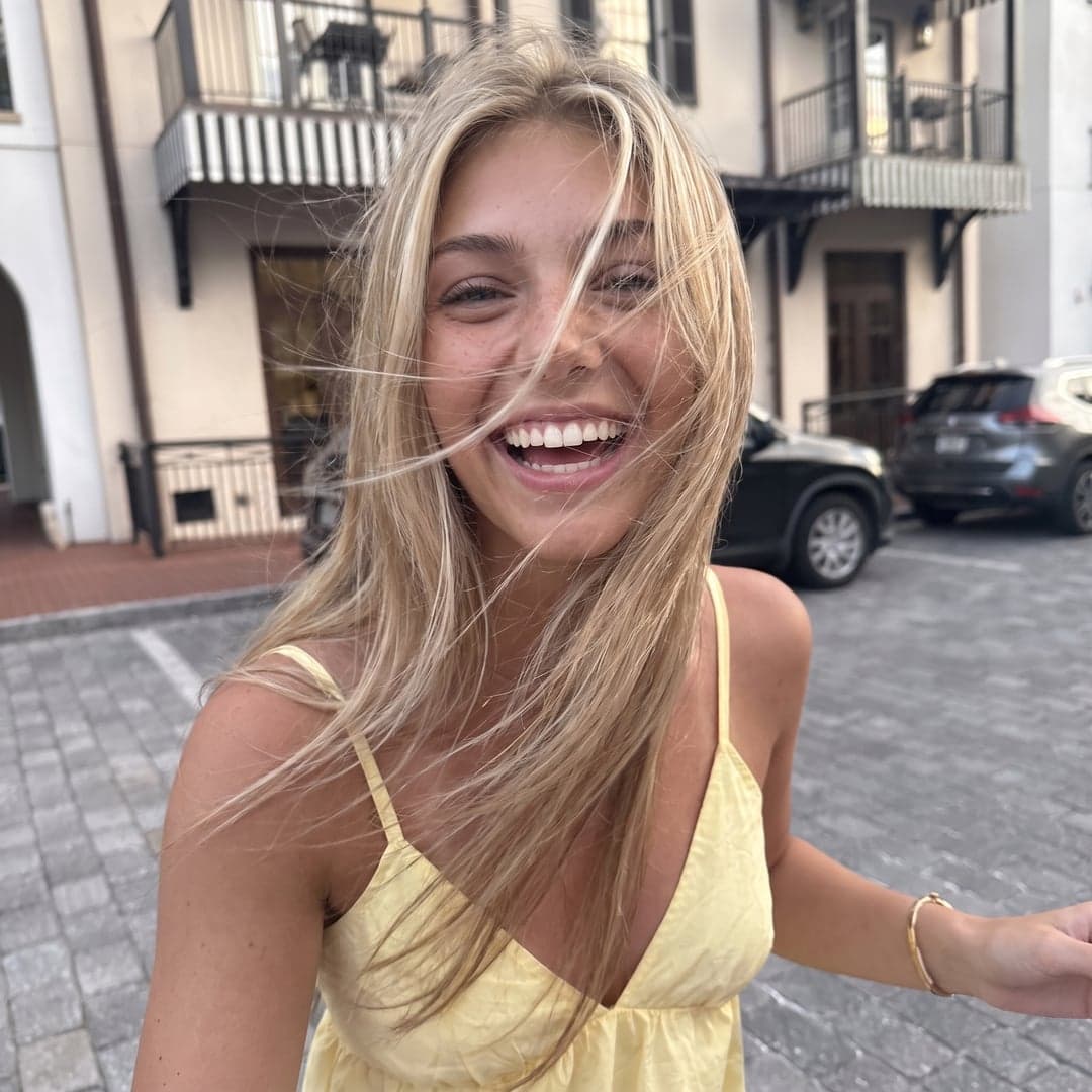 La même femme blonde qui rit dans une robe jaune